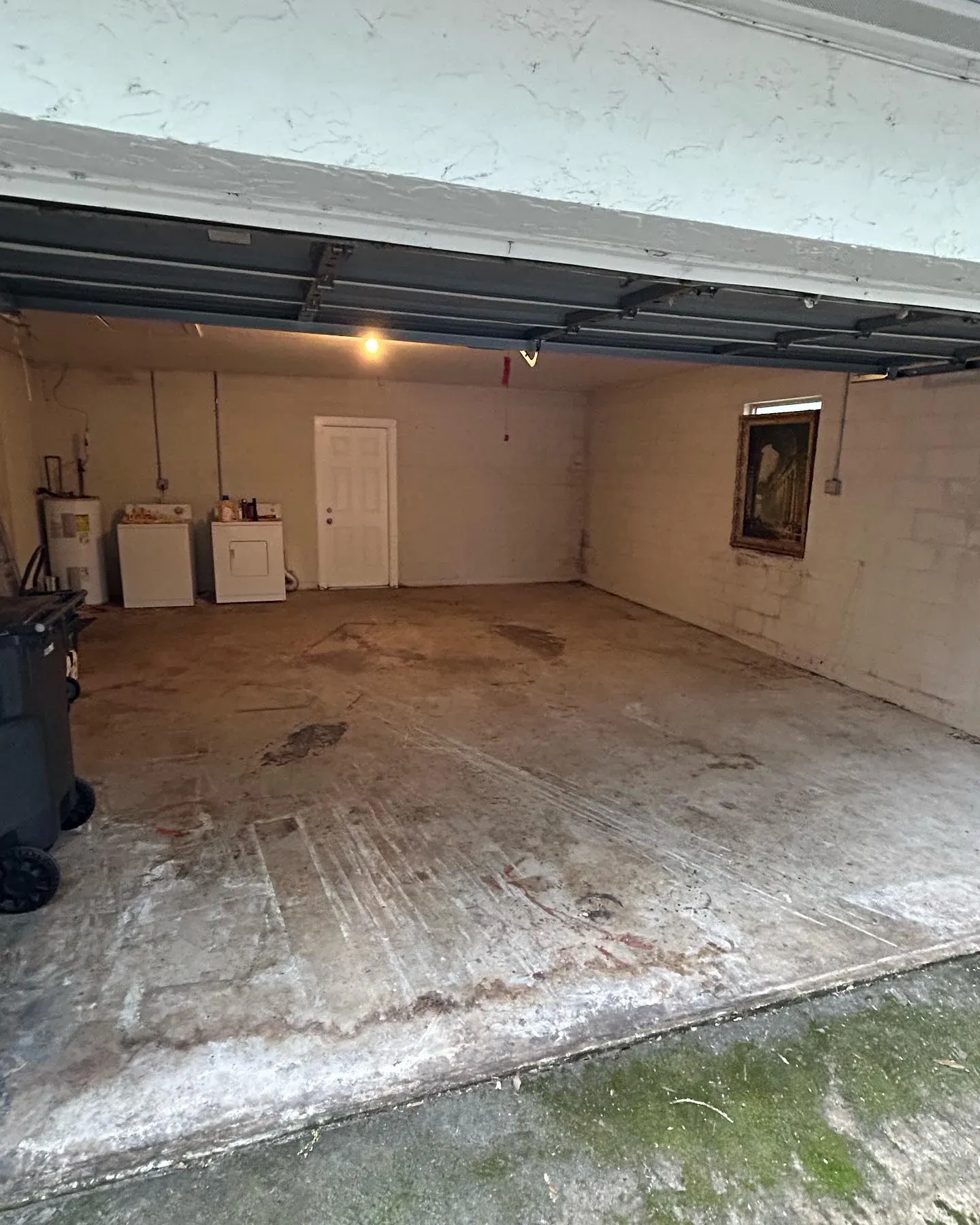 After view of a clean and empty garage with bare concrete floor following professional garage clearance and junk removal service