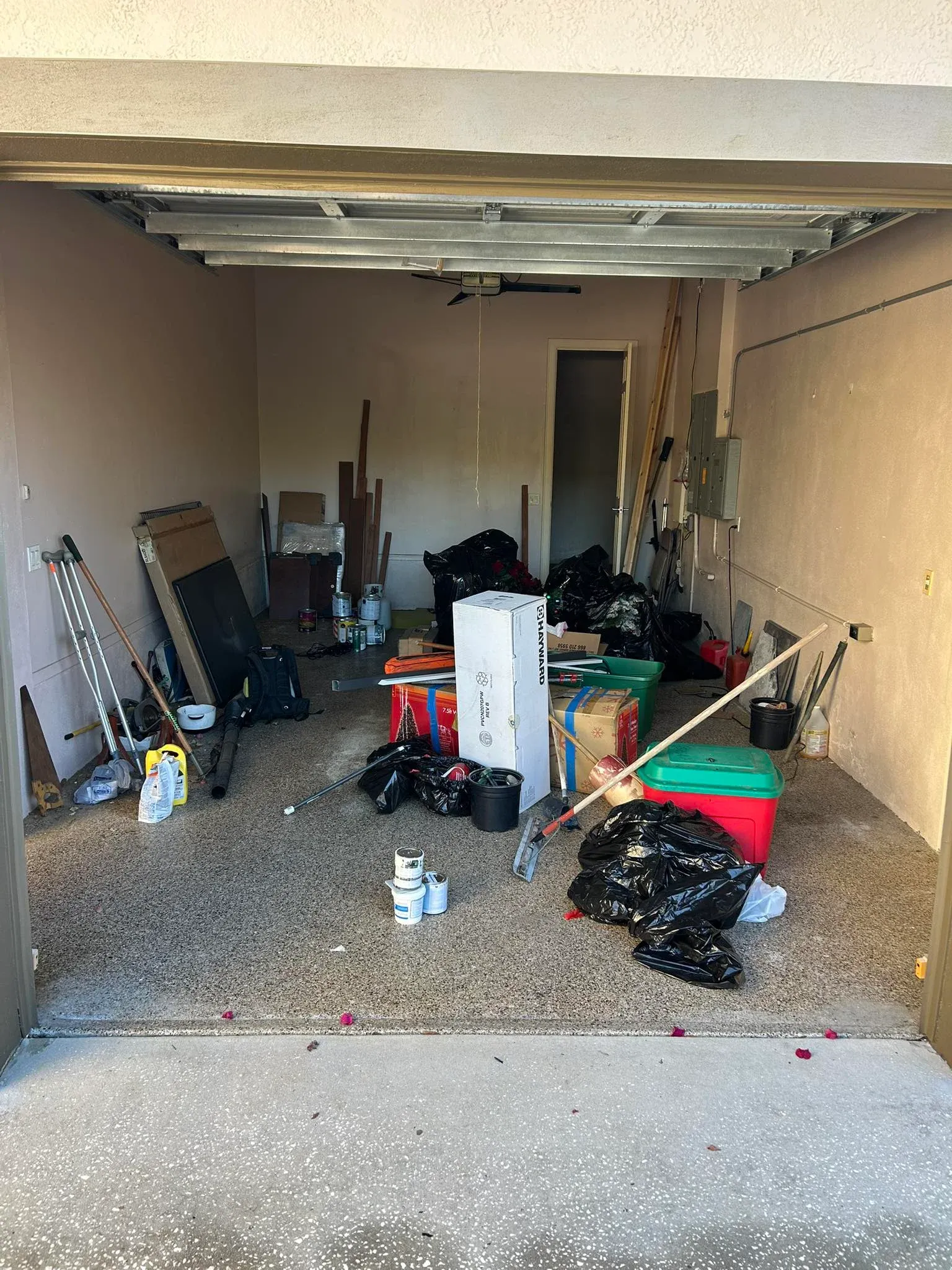 Before view of a cluttered and messy garage filled with tools equipment and unwanted items prior to clearance service