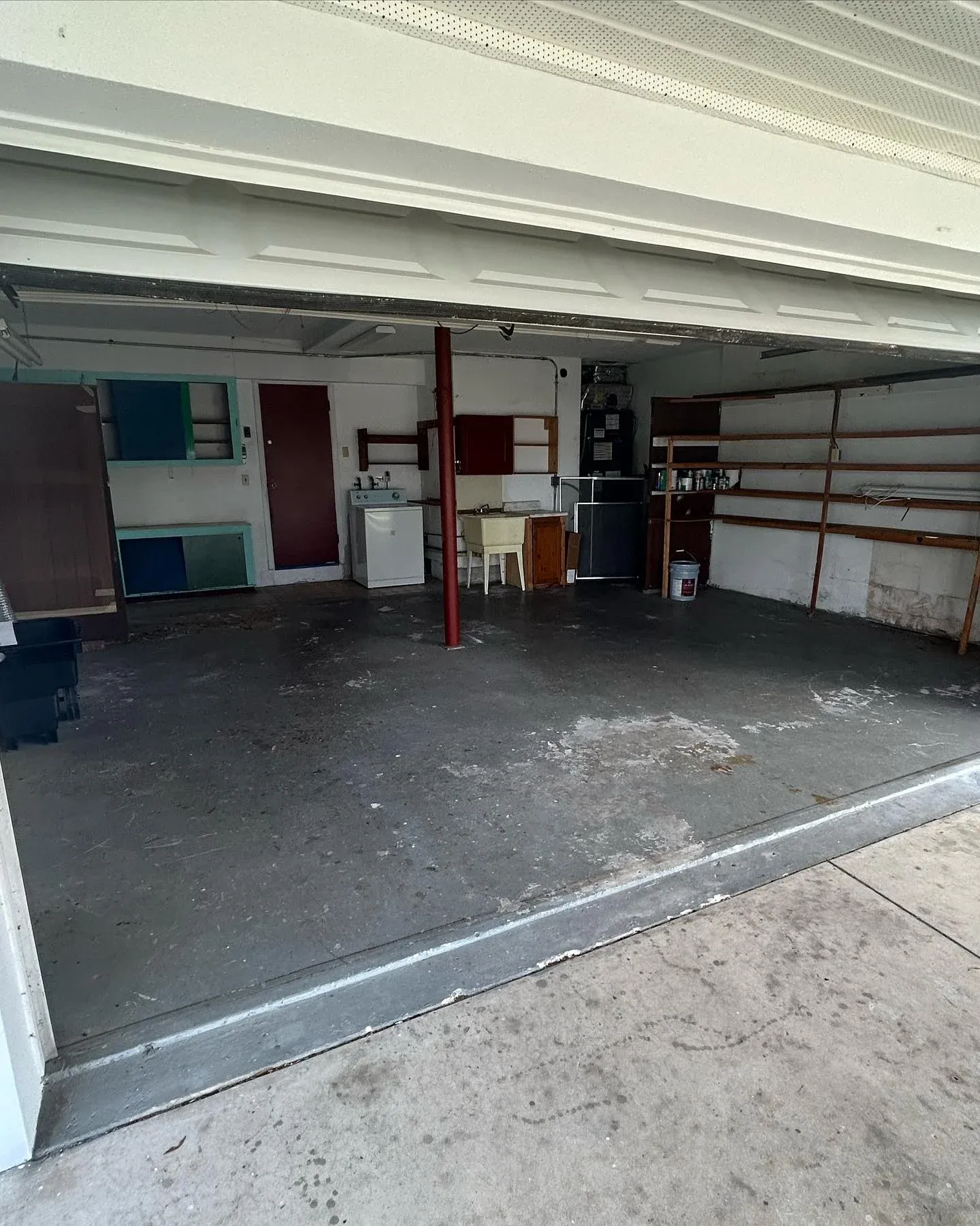 After view of a clean and empty garage with smooth concrete floor and open space following professional garage clearance