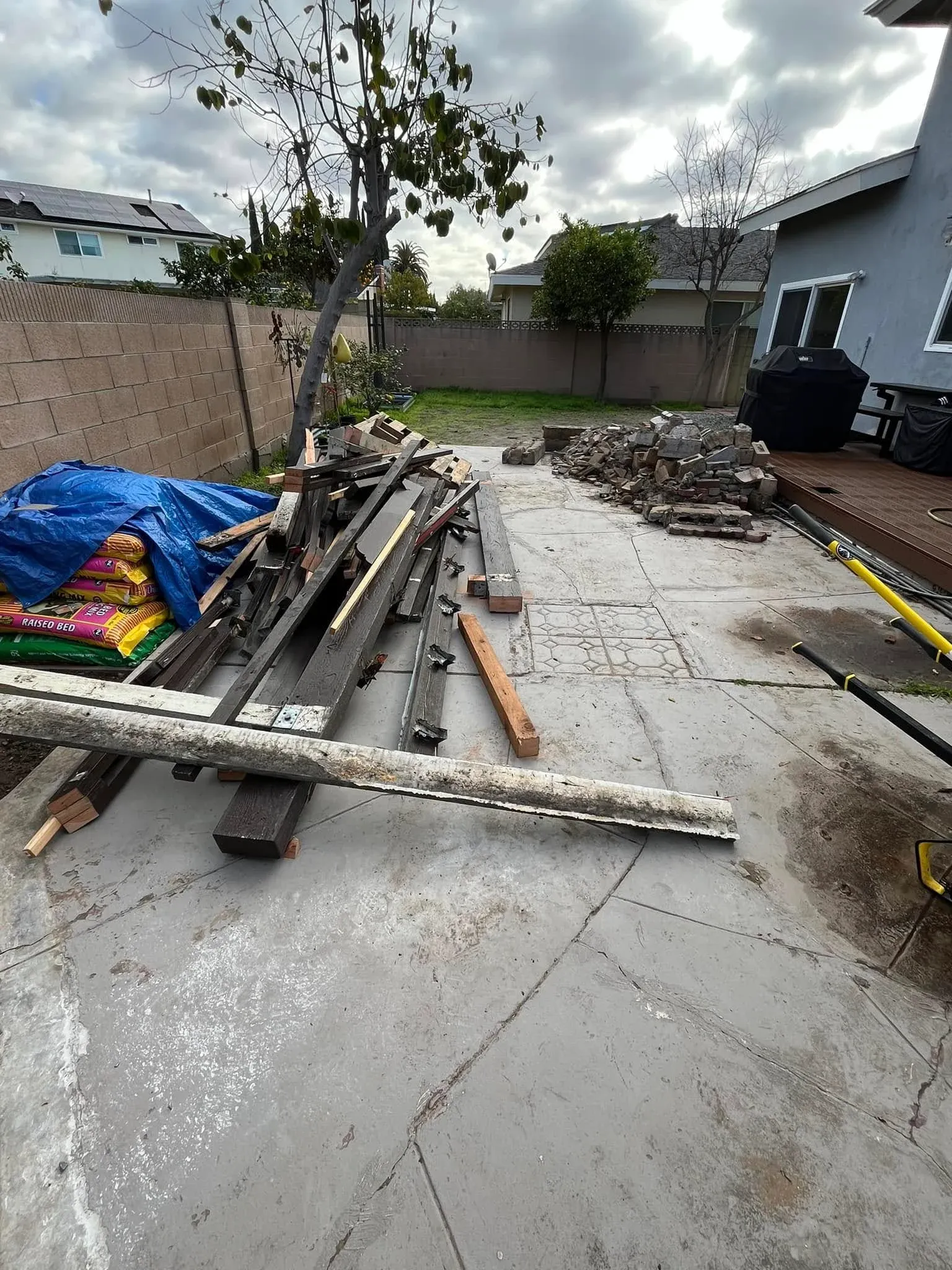 Before view of a cluttered driveway and outdoor area before garden clearance and junk removal