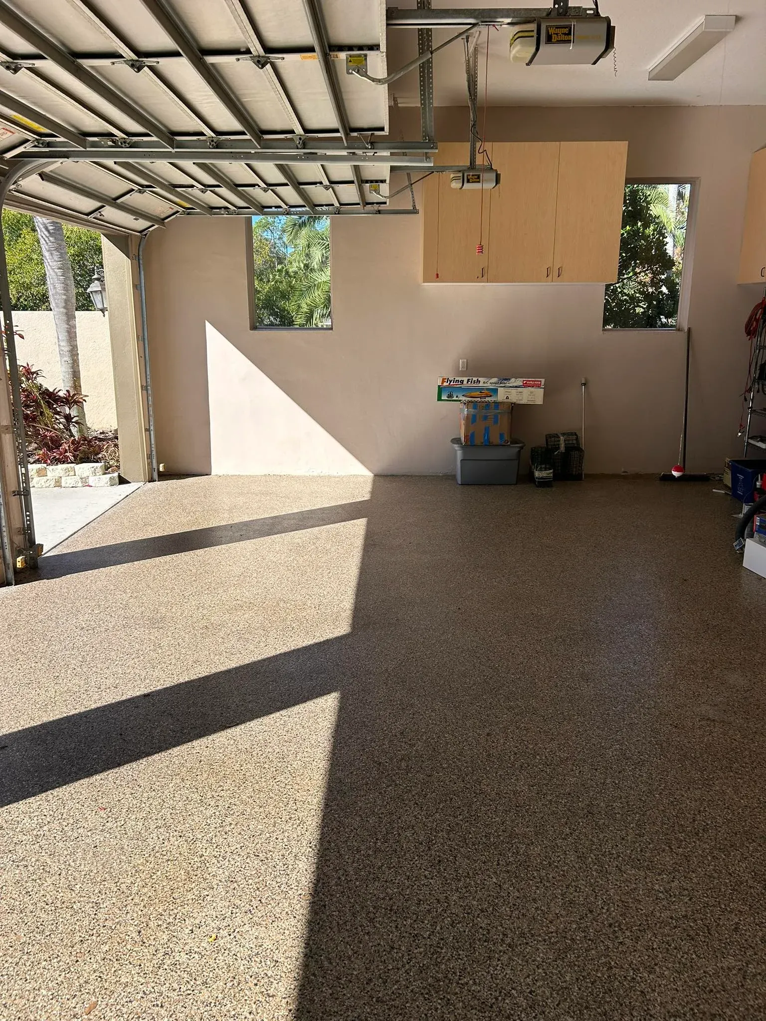 After view of a clean and cleared open patio and garage area with tiled floor following professional junk removal service