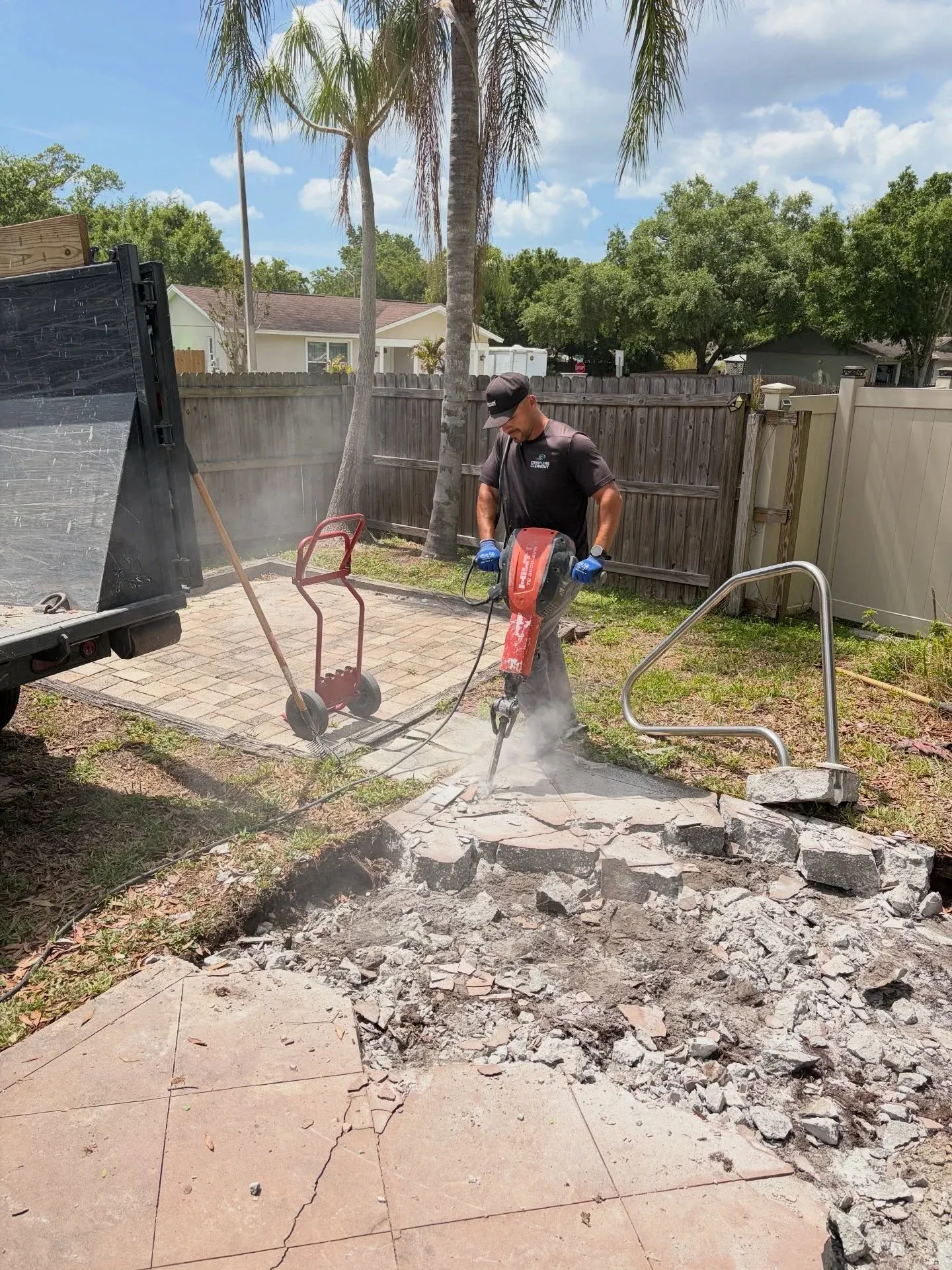 Before view of a worker demolishing and breaking up concrete and rubble in an outdoor area prior to clearance