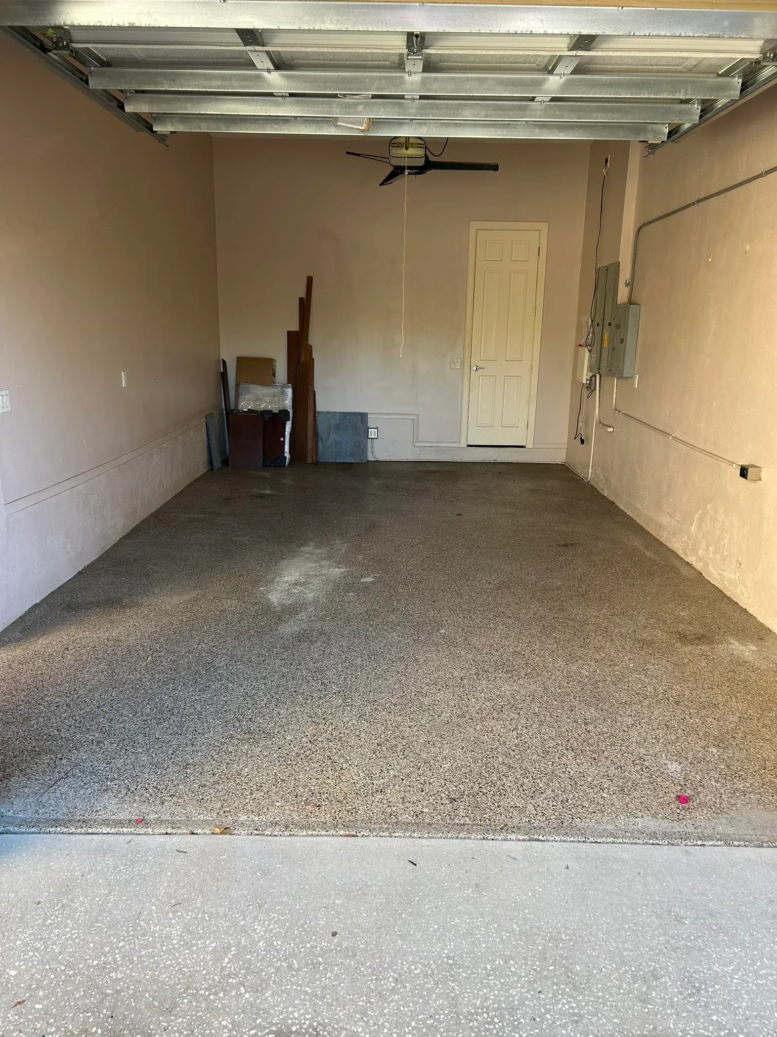 After view of a clean and cleared empty garage with bare concrete floor following professional garage clearance service