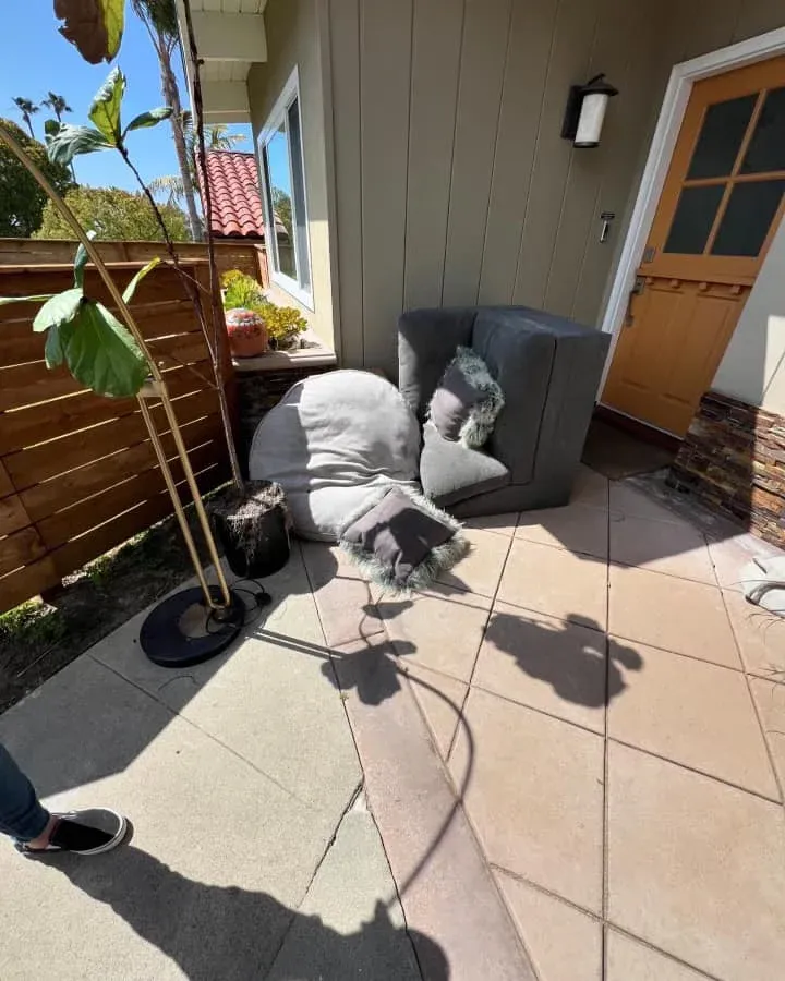 Before view of a cluttered side garden area with debris and unwanted items prior to professional clearance service