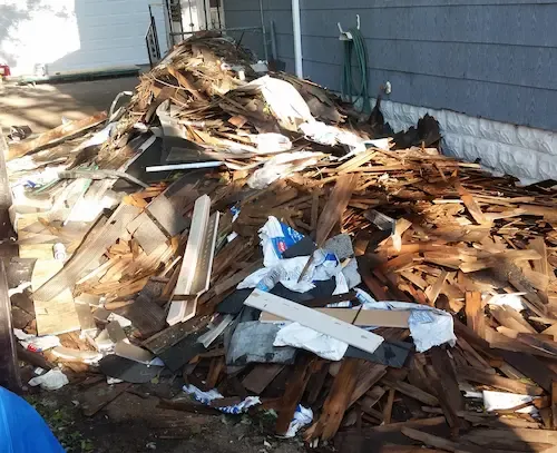 Before view of a large pile of broken wood timber and rubbish outside a property prior to clearance service